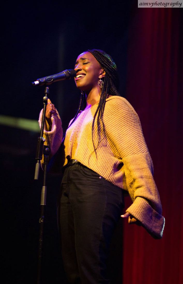 A young performer singing at a You Press event